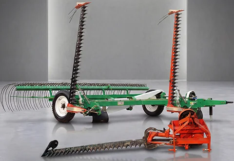 Sickle bar mower attachment mounted on a tractor.