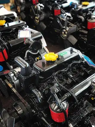 Rows of genuine diesel tractor engines stocked in XT-AGRO factory warehouse ready for assembly or spare parts dispatch.