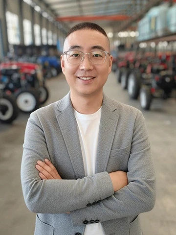 Dean Zhang, Director of International Trade at XT-AGRO, standing in the tractor manufacturing facility.